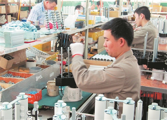 精准机械车间内工人正在组装送纱器